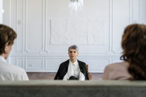 man in black suit sitting on brown couch